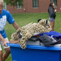 Volunteer with moving bin full of items